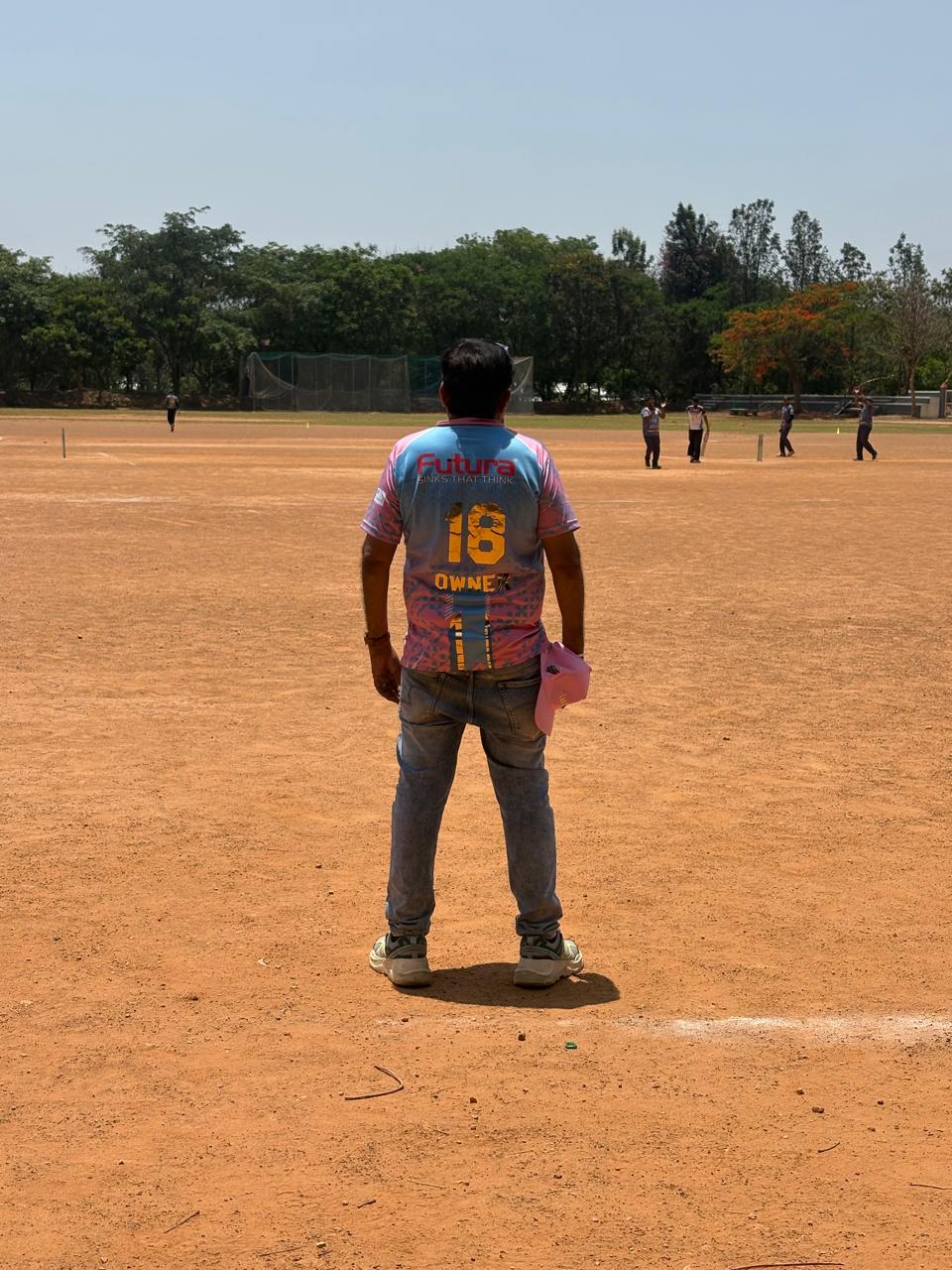 Participant wearing a Futura branded cricket jersey at the Siwanchi Jain Yuva Mandal cricket tournament on a cricket ground in Bangalore.