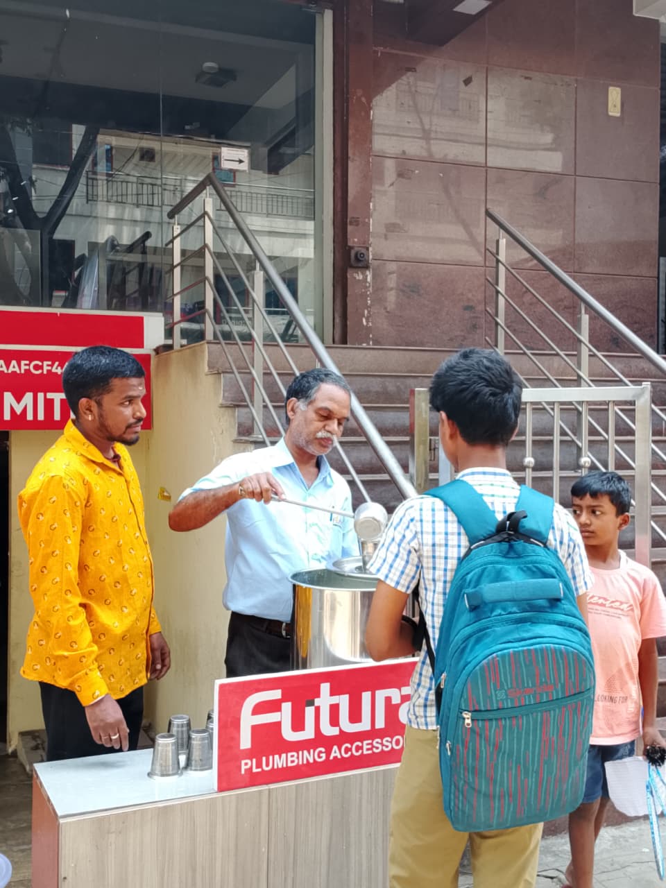 Futura staff serving free buttermilk to school students and pedestrians during a summer CSR initiative in Bengaluru.